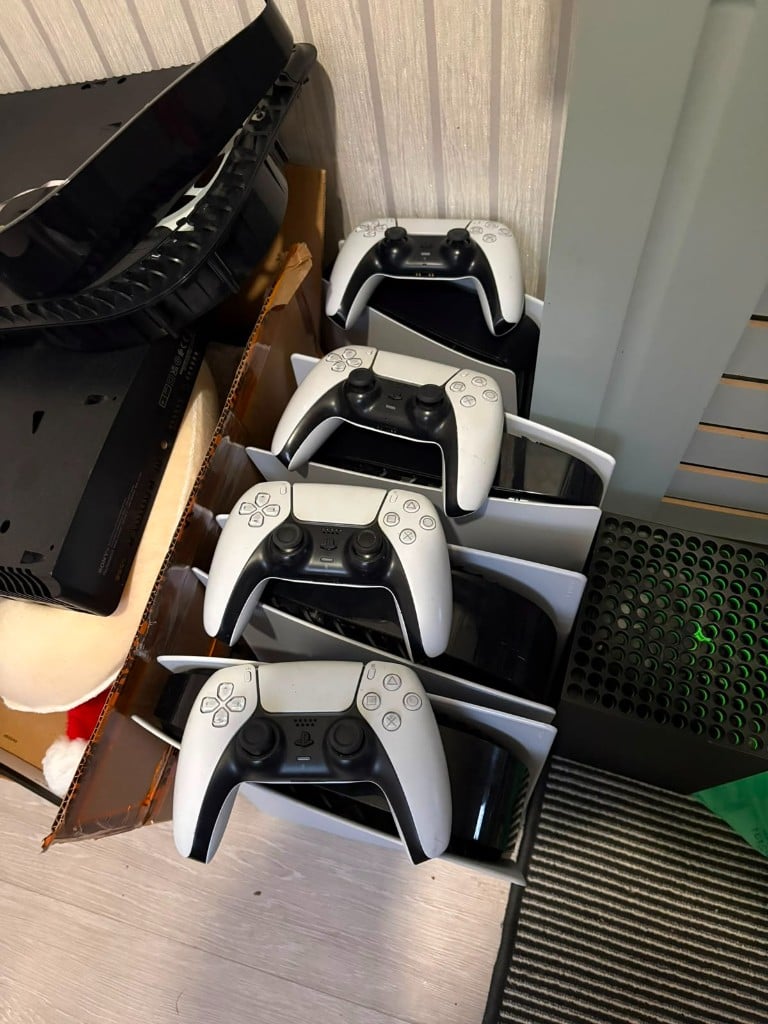 PlayStation 5 consoles and DualSense controllers beside an Xbox Series X